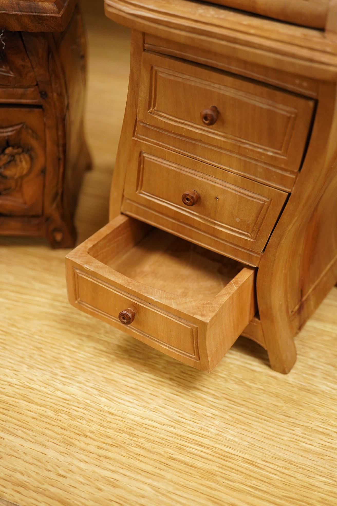 Two Piere Decorse (b.1953), a naturalistically modelled sculpture of a miniature carved novelty bureau and a sideboard, both surmounted with books and a lamp, largest 39cm high